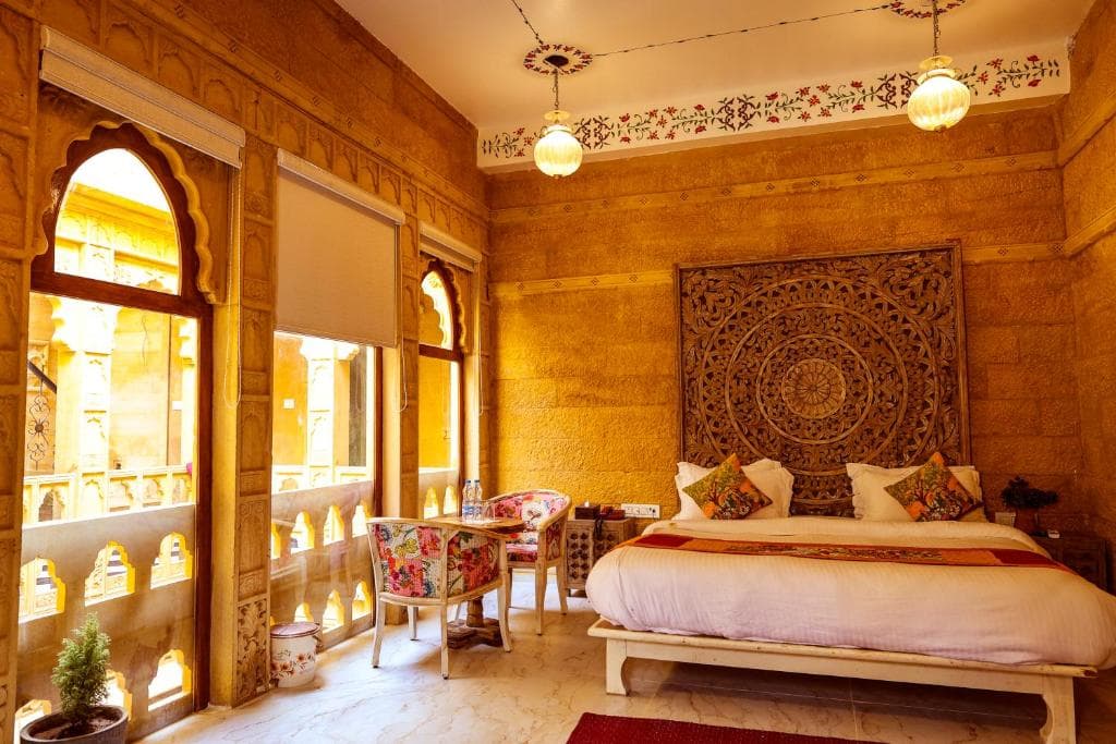 A king room with carved sandstone arches and a balcony over the old city